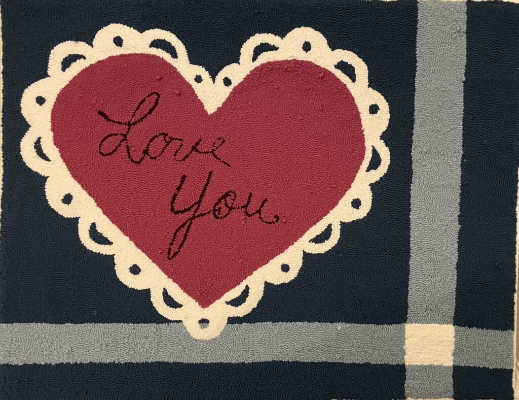 Rug with a heart in the center that says "love you"